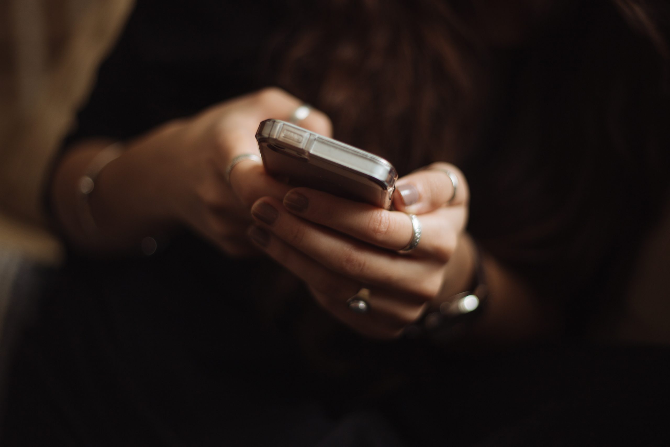 Person using a cellphone, resources and helplines for domestic violence